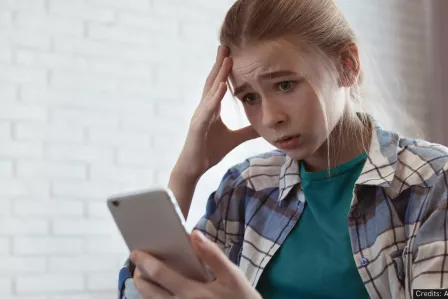 Worried girl looking at her phone