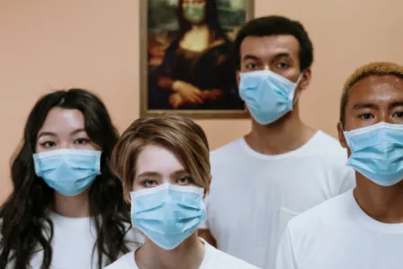 Four young people wearing surgical masks