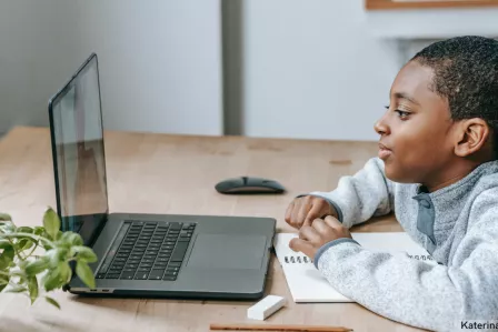 Black boy watching video on laptop