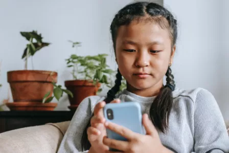 Young girl looking concerned at her smartphone