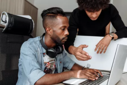 Group of young people facing a computer
