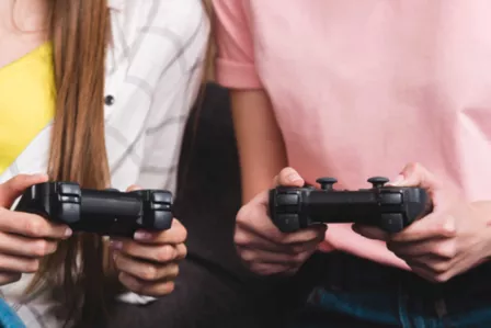 Boy and girl playing with a game console in their hand