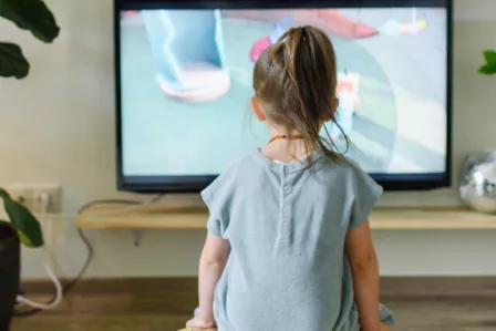 Young child in front of large TV screen