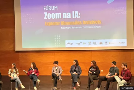 Birdview of the conference venue with the stage and a panel of eight young people