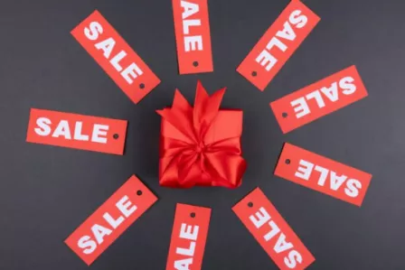 Wrapped gift surrounded by sale tags