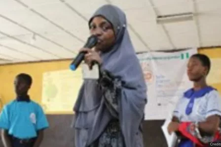 A young girl giving a speech in her classroom