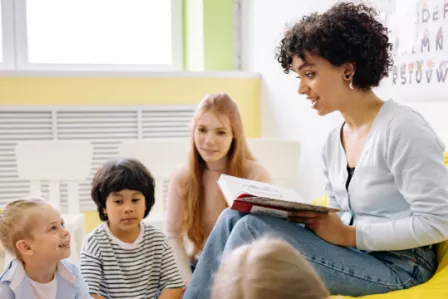 A school teacher reading a book to her pupils