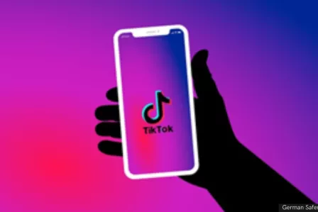 Shadow hand holding a phone with "Tik Tok" written inside