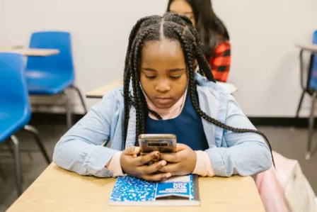 Girl looking at smartphone in a classroom