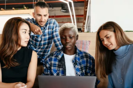 Group of young people around a laptop
