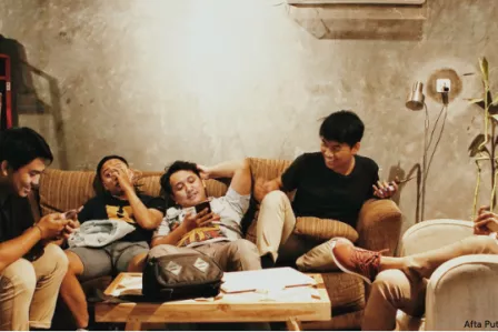 Young people on the couch, playing on their phone