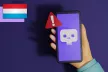 A person holding a phone with a danger sign on the screen.