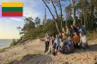 Group picture of all the camp participants on a beach at sunset