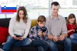 A mom and dad with their two kids all on their phone 