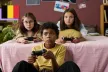 Two young girls and a young boy playing videogames and holding controllers