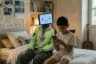 robot and kid sitting on bed talking