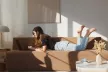 Girl lying on a sofa using a laptop