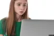 scared teenage girl in front of a laptop
