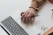 Birds-eye view of hands on a laptop keyboard