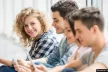 Young people sitting on the floor with digital devices