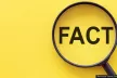 Fact - word through magnifying glass on a yellow background