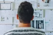 Back view of a man looking at a notice board with lots of posts on it