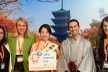 Panel of conference goers smiling at the camera on a japanese-styled background