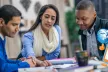Three people discussing over a document