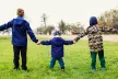 Three boys holding hands outside