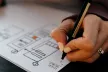 Person mapping out user goals with a pen and paper