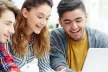 Three smiling teens, using a tablet together