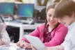 Children using devices in a classroom setting