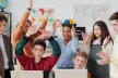 Group of cheerful young students and a teacher in front of two laptops