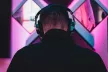 Rear view of a male teenager wearing over ear headphones
