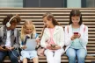 Young people looking at their phones and electronic devices