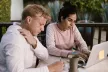 Adults studying at a desk with a laptop