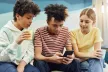 Three children looking at smartphone