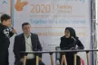 A young person, on stage, interviewing two speakers at the Safer Internet Day event in Iran