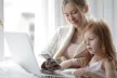 Mother and daughter using a laptop and mobile device together