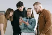 Four young people looking at a smartphone