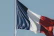 The writing "#SID2023" in the foreground of a waving French flag 