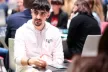 Young man sitting at a roundtable, many people sitting in the background