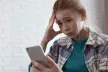 Worried girl looking at her phone