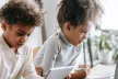 A young boy and girl looking at a tablet and laptop