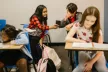 Children sat at desks in a classroom setting