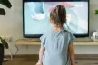 Young child in front of  large TV screen