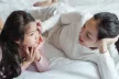 A mother speaking to her daughter on a bed