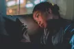 Teenager looking at a phone screen against a darkened backdrop