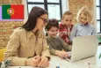 Digital literacy. Kids learn using laptop with teacher.