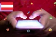 View of two hands tapping on a smartphone screen, and lots of social media icons surrounding the phone.